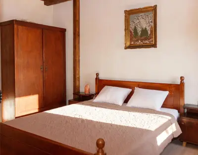 a bedroom with a bed and a wooden cabinet at Old stone house with swimming pool Etno House Perazic in Bar