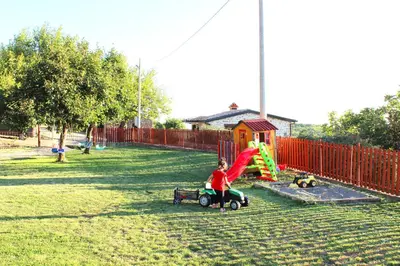 a young child playing on a playground at Old stone house with swimming pool Etno House Perazic in Bar