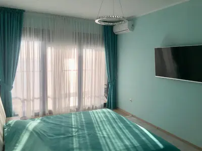 a bedroom with a green bed and a television at Аpartment 555 in Dobra Voda