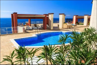 a swimming pool on top of a building with the ocean at Аpartment 555 in Dobra Voda
