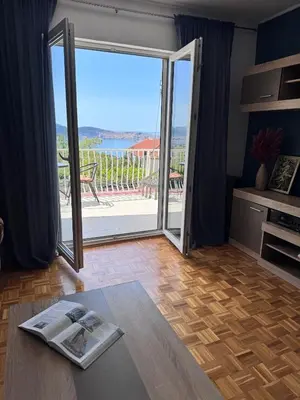 a living room with a door open to a patio at Apartment Serenada in Bar, Susanj