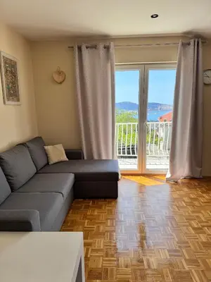 a living room with a couch and a large window at Apartment Serenada in Bar, Susanj