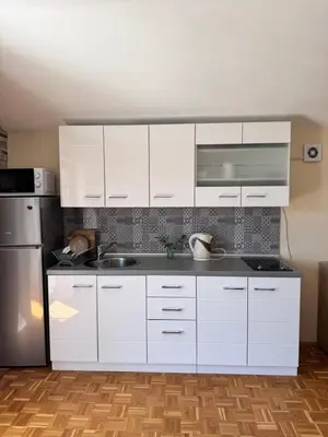 a kitchen with white cabinets and a stainless steel refrigerator at Apartment Serenada in Bar, Susanj
