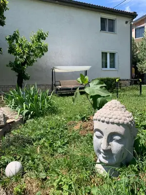 a statue of a head in the yard of a house at Apartment Serenada in Bar, Susanj