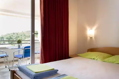 a bedroom with a bed and a window with a balcony at Apartments Đurović in Petrovac na Moru