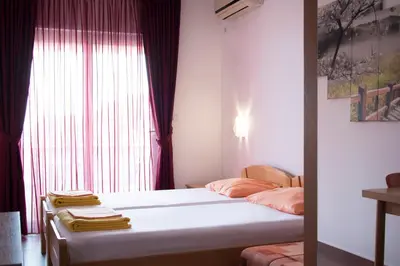 a bedroom with a large bed with a window at Apartments Đurović in Petrovac na Moru