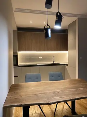 a kitchen with a wooden table and blue chairs at Apartman VT Central point in Podgorica