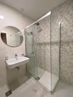 a bathroom with a glass shower and a sink at Apartman VT Central point in Podgorica