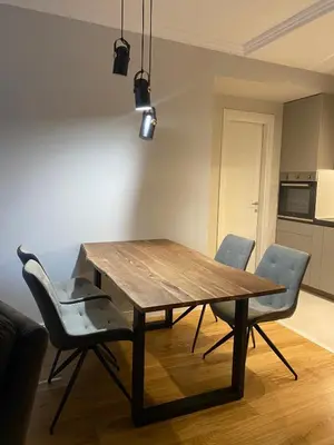a dining room table with two chairs and a kitchen at Apartman VT Central point in Podgorica
