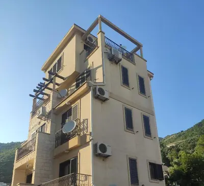 a tall building with a balcony on the side of it at Petrovac Sea in Petrovac na Moru
