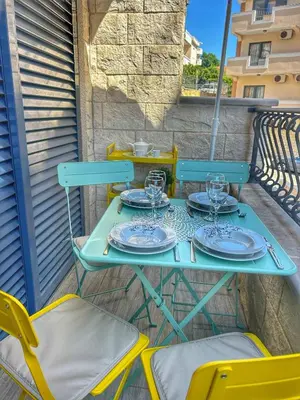 a table with plates and glasses on a balcony at Petrovac Sea in Petrovac na Moru
