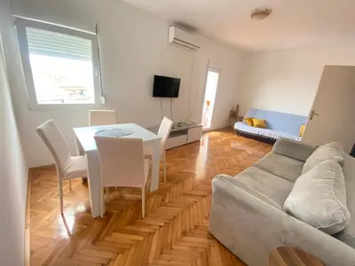 a living room with a couch and a table and chairs at Two-bedroom apartment with parking and sea view in Becici