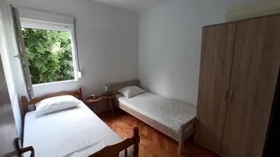 a small room with two beds and a window at Two-bedroom apartment with parking and sea view in Becici
