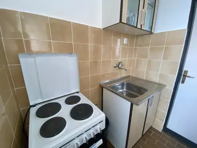 a small kitchen with a stove and a sink at Two-bedroom apartment with parking and sea view in Becici
