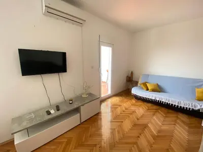 a living room with a couch and a flat screen tv at Two-bedroom apartment with parking and sea view in Becici
