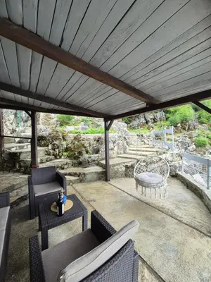 a patio with chairs and a table and a roof at Old house, Skadar Lake in Cetinje