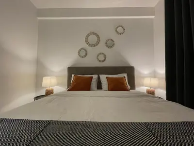 a bedroom with a bed with two lamps and plates on the wall at YOUR CHOICE in Bar
