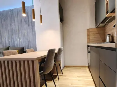 a kitchen with a wooden table and chairs at Becici stan in Budva