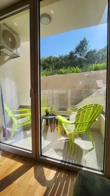 a balcony with a green chair and a table at Becici stan in Budva
