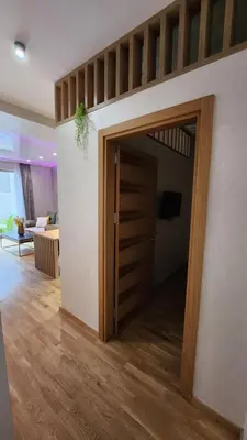 a room with a wooden door and a living room at Becici stan in Budva
