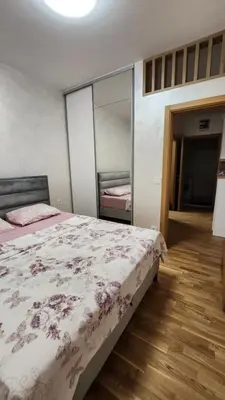 a bedroom with a bed and a mirror at Becici stan in Budva