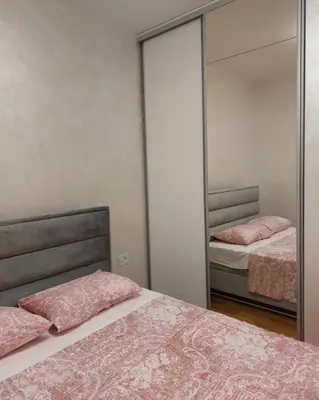 a bedroom with two beds and a mirror at Becici stan in Budva