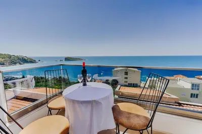 a table with a bottle of wine on a balcony at Enchanted April in Utjeha