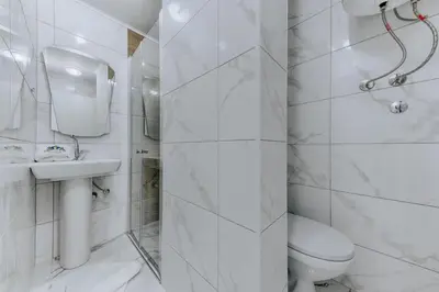 a white bathroom with a toilet and a sink at Enchanted April in Utjeha