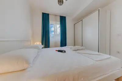 a bedroom with a large white bed with a large mirror at Enchanted April in Utjeha