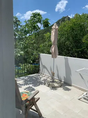 an umbrella and a chair on a patio at Apartment Centar in Buljarica