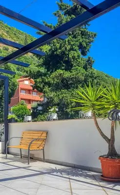 a bench sitting on a wall next to a plant at Apartmani Terminal in Budva
