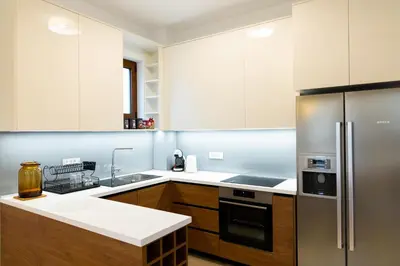 a kitchen with white cabinets and a stainless steel refrigerator at Villa Forte Mare in Petrovac na Moru