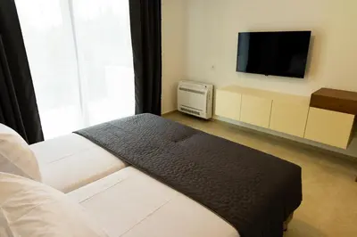 a room with a bed and a tv and a couch at Villa Forte Mare in Petrovac na Moru