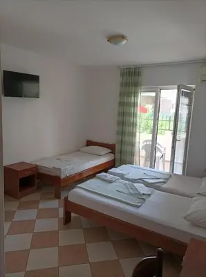 a room with two beds and a tv and a window at Apartmani Baštrica in Budva