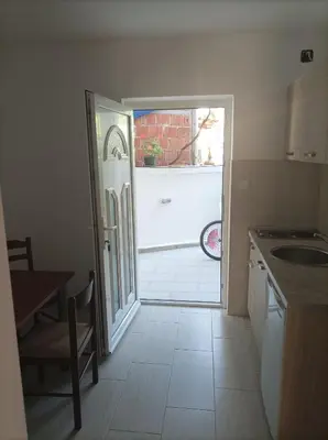 a kitchen with a door leading to a garage at Apartmani Baštrica in Budva