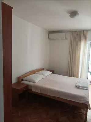 a small bedroom with a bed and a window at Apartmani Baštrica in Budva