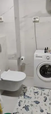 a bathroom with a toilet and a washing machine at Todor apartment in Bar