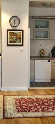 a kitchen with a white wall with a clock on it at Todor apartment in Bar