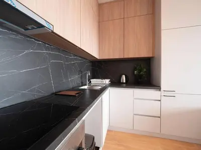 a kitchen with white cabinets and a black counter top at Lovely Partial Sea View one bedroom Flat in Horizon Residences A24 in Becici