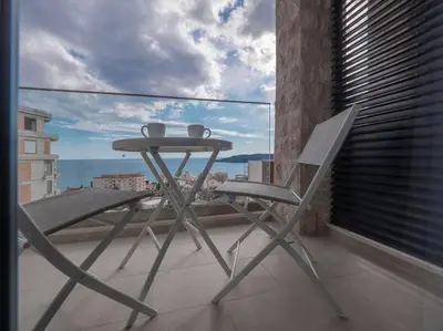 a table and chair on a balcony with a view at Lovely Partial Sea View one bedroom Flat in Horizon Residences A24 in Becici