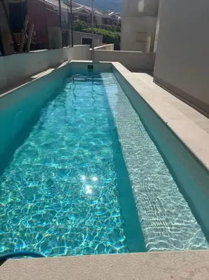 a swimming pool with blue water in a building at Lovely Partial Sea View one bedroom Flat in Horizon Residences A24 in Becici