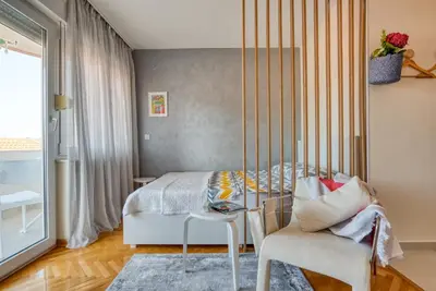 a bedroom with a bed and a table and a chair at Cozy studio in Petrovac with sea view in Petrovac na Moru
