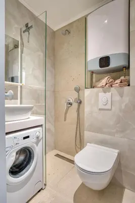 a bathroom with a toilet and a sink and a washing machine at Cozy studio in Petrovac with sea view in Petrovac na Moru