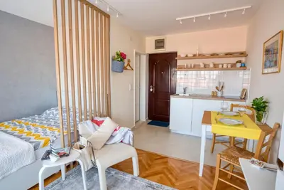 a room with a bed and a table and a kitchen at Cozy studio in Petrovac with sea view in Petrovac na Moru