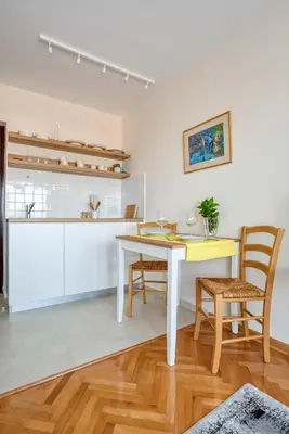 a kitchen and dining room with a table and chairs at Cozy studio in Petrovac with sea view in Petrovac na Moru
