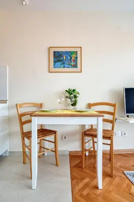 a white dining room table with chairs in a room at Cozy studio in Petrovac with sea view in Petrovac na Moru