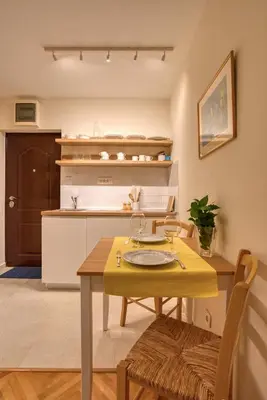 a kitchen with a table and a yellow table and chairs at Cozy studio in Petrovac with sea view in Petrovac na Moru