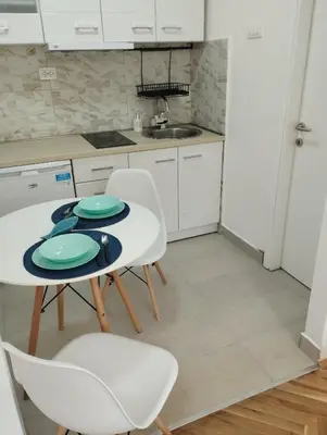 a kitchen with a table and two chairs and a sink at Apartment Cattaro magico in Kotor