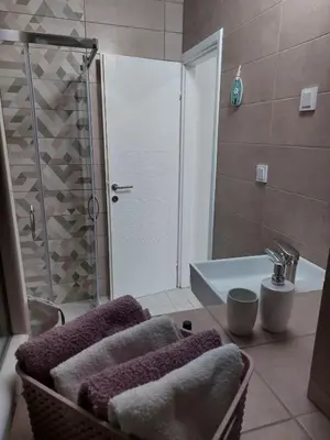 a bathroom with a shower and a sink with towels at Apartment Cattaro magico in Kotor
