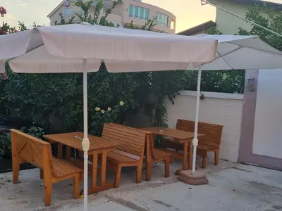 a table and chairs with an umbrella on a patio at Vila DUBAI - ULCINJ VELIKA PLAŽA in Ulcinj